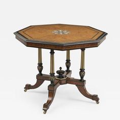 an ornate wooden table with gold trimmings on the top and two columns at the base