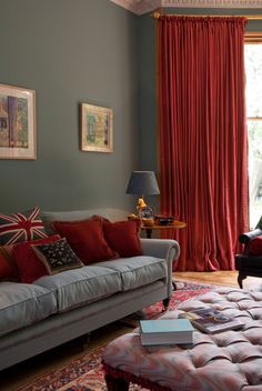 a living room filled with furniture and red curtains