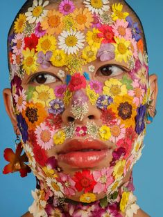 a woman's face is covered in flowers and has butterflies all over her body