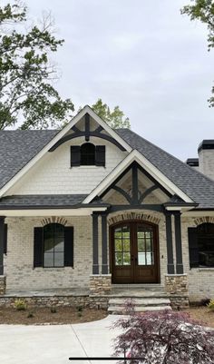 a white brick house with black shutters on the front door and windows in the middle