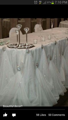 the table is set with white linens and silverware