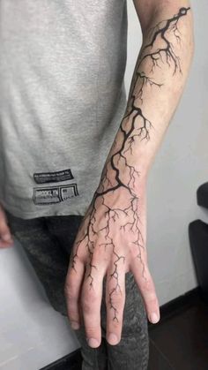 a man's hand with a lightning tattoo on his left arm and the wrist