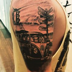 a man with a tattoo on his arm has a vw bus and street signs