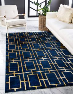 a living room with a couch, chair and rug in blue and gold color scheme