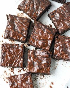 chocolate brownies are sitting on a white cutting board