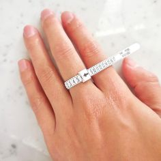 a woman's hand with a measuring tape ring on top of her finger,