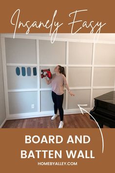 An image of a girl holding a nail gun in front of a board and batten wall. The text says "Insanely Easy Board and Batten Wall" Easiest Accent Wall, Navy Batten Board Wall, Diy Panelled Walls, Board And Batten Wall Spacing, Board And Batten Wall Window, Whole Room Board And Batten, White Batten Board Walls, Diy Decorative Wall Panels, How To Measure For Board And Batten Wall