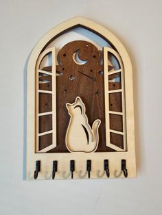 a wooden clock with a cat sitting in the window