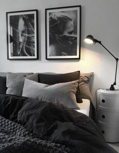 a bedroom with two pictures on the wall above the bed, and a lamp next to it