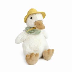 a white stuffed duck wearing a yellow hat and green checkered scarf on its neck