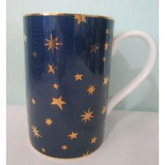 a blue and gold coffee cup with stars on it