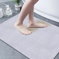 a woman's bare feet standing on a bathroom rug