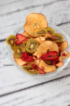 a glass bowl filled with sliced kiwis and strawberries