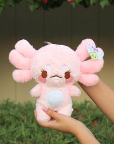 a person holding a pink stuffed animal in their hand