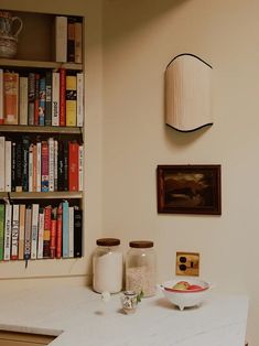 a room with bookshelves and various items on the table