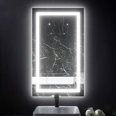 a bathroom sink with a lighted mirror above it