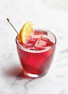 a close up of a drink in a glass with a lemon slice on the rim