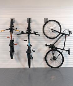 two bikes are hanging on the wall and one is upside down