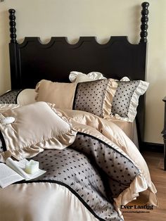 a bed with black headboard and polka dot sheets