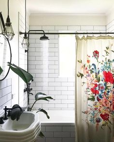 a bathroom with a sink, shower curtain and tiled walls is shown in this image