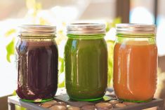 three mason jars filled with different colored liquid