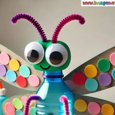 a colorful insect made out of plastic bottles with eyes and antennae on it's head