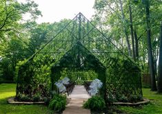 an outdoor ceremony setup with white flowers and greenery