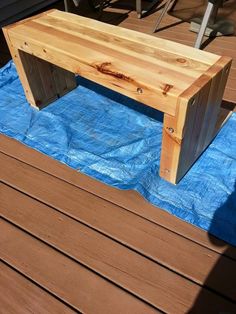 a wooden bench sitting on top of a blue tarp