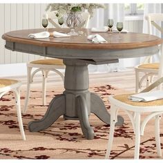 a dining room table with chairs around it and a rug on the floor next to it