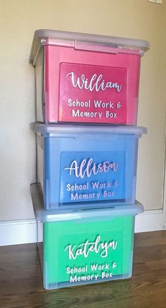 three plastic storage containers sitting on top of a hard wood floor next to a wall