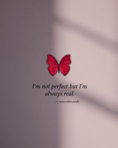 a red butterfly sitting on top of a white wall next to a quote that says i'm not perfect but i'm always real