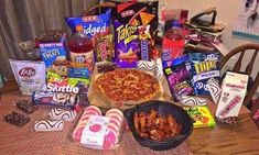 a table topped with lots of snacks and food items on top of a wooden table