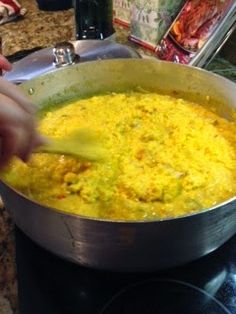 a person stirring food in a pot on the stove