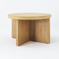 a round wooden table sitting on top of a white floor