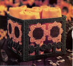 two candles are in a basket with flowers on the table next to some other items