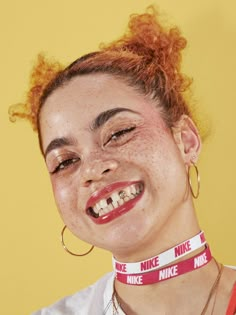 a woman with freckles on her face wearing a red neckband and smiling