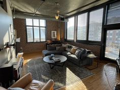 a living room filled with furniture and large windows