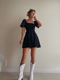 Dress With Cowboy Boots Concert, Concert Cowboy Boots Outfit, Black Dress And White Boots, Slip Dress With Cowgirl Boots, Black Dress For Concert, Colored Cowboy Boots Outfit, Cute Cowgirl Dress Outfits, Cowgirl Outfits Brown Boots, All Black Cowboy Boots Outfit