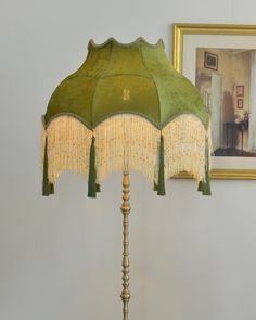 a lamp that is on top of a wooden table next to a framed photo and a painting