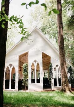 a white church surrounded by trees and grass