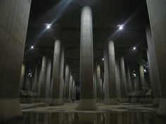 an empty room with columns and lights in it