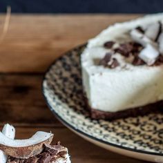 a piece of cheesecake on a plate next to another slice with chocolate and marshmallows