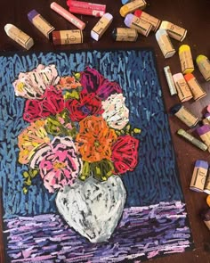 an art project with crayons and pastels on the table next to it