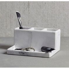 the toothbrush holder is made out of marble and holds two different types of tools