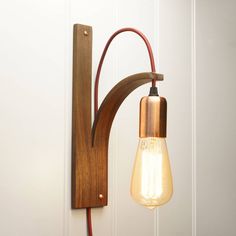 a light that is on the wall next to a wooden frame with a lamp in it