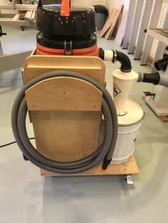 a vacuum is sitting on top of a wooden box with a hose attached to it