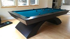 a pool table in the middle of a room with two windows and a remote control