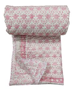 the pink and white floral print blanket is folded up