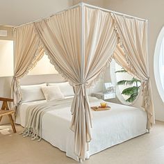 a white bed sitting in a bedroom next to a round window