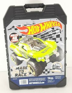 a yellow toy truck in a black plastic case on a white surface with words hot wheels made to race